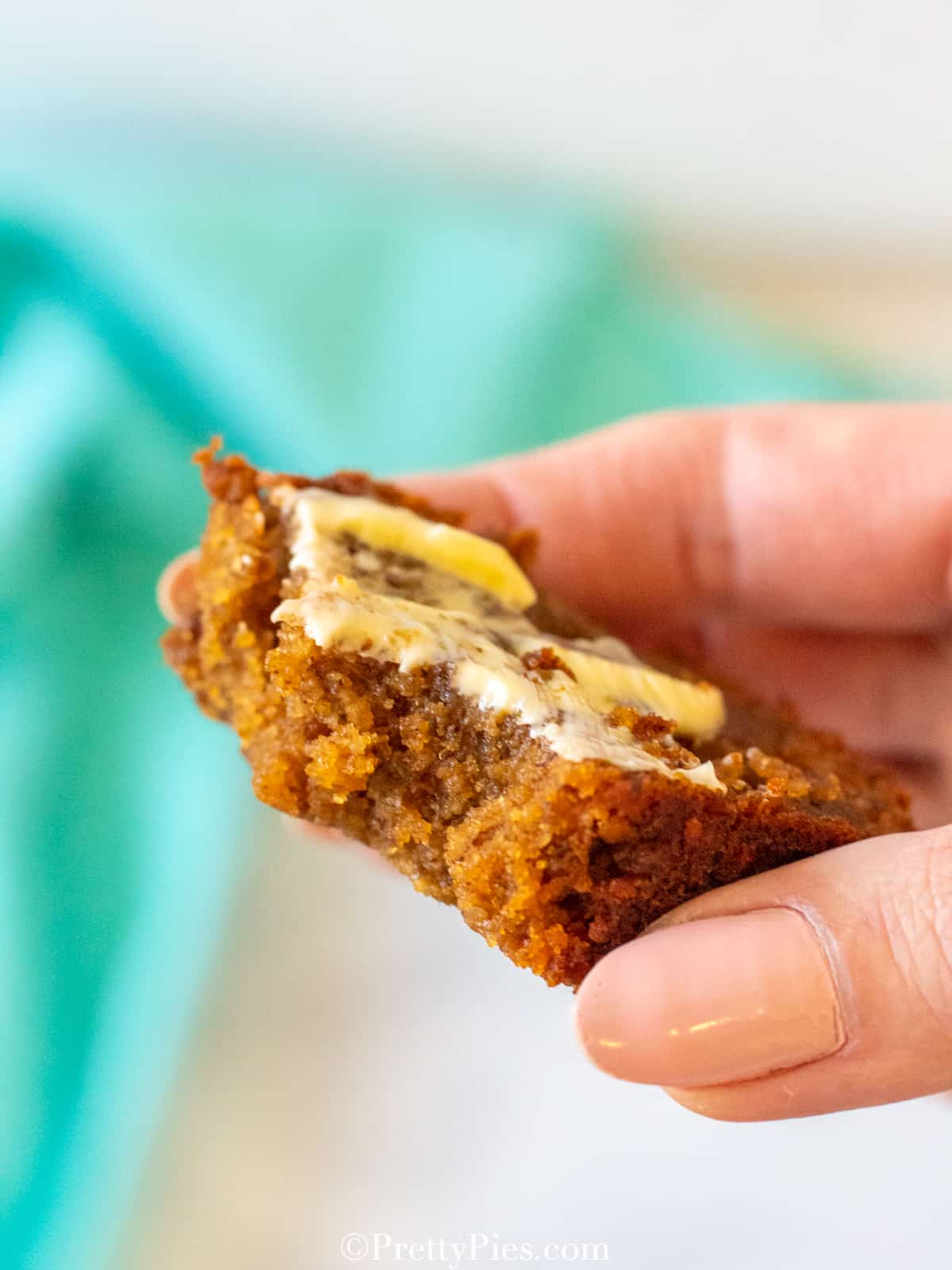 low carb Pumpkin Bread loaf slice with butter bite shot in hand