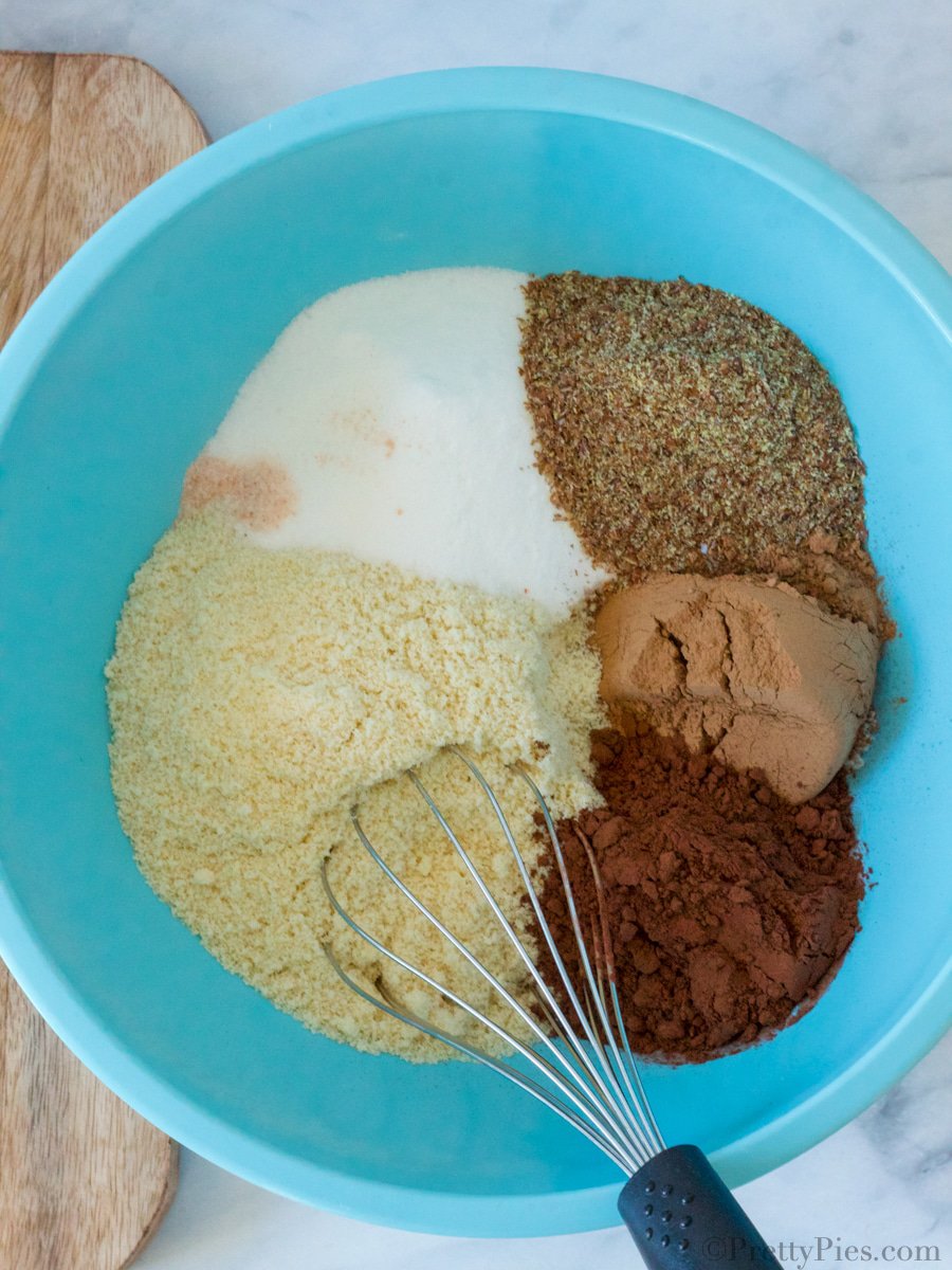 dry brownie ingredients in a mixing bowl with a whisk